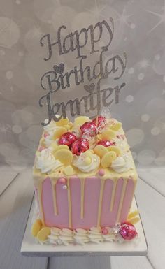 a birthday cake with white frosting and pink icing