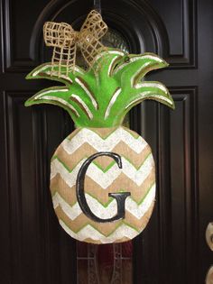 a pineapple door hanger with the letter g on it