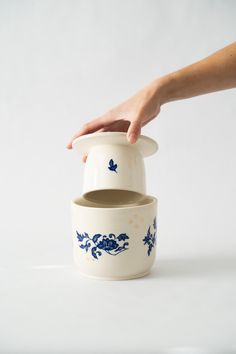 a hand reaching into a blue and white container