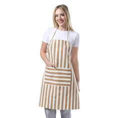 a woman wearing an apron and smiling at the camera with her hands in her pockets