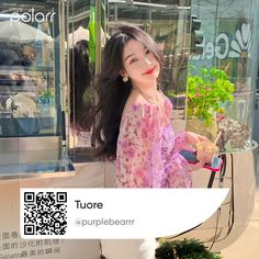 a woman standing in front of a store window holding a cell phone and potted plants