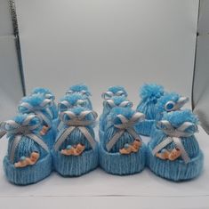 six blue knitted baby booties with bows on them