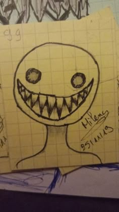 a piece of paper with a drawing of a smiling monster on it's face