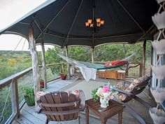 an outdoor deck with hammock and chairs