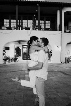 a man and woman kissing in front of a building