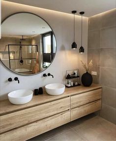 a bathroom with two sinks and a large round mirror above the sink in front of it