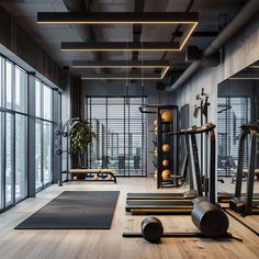 an empty gym with exercise equipment and yoga mats in front of large windowed windows