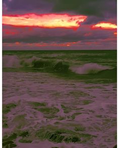 the sun is setting over the ocean with waves crashing in front of it and pink clouds