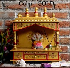 a yellow and red cabinet sitting on top of a table next to a brick wall