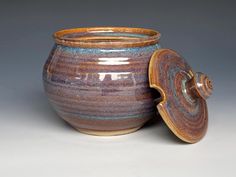 a brown and blue ceramic jar with lid