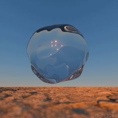 a large bubble floating in the air over a desert