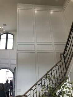 the stairs are lined with white paneling and black railings