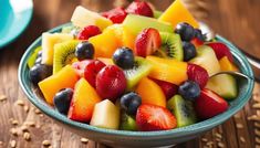 fruit salad with kiwi, oranges, strawberries and blueberries in a bowl