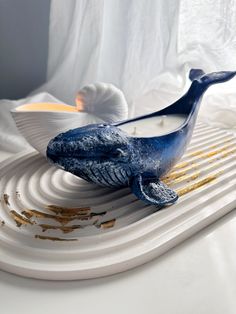 a blue whale sitting on top of a white plate