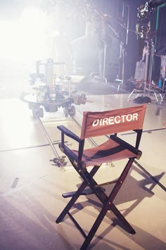 a director's chair sits in the middle of a stage with lights behind it