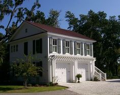 a white house with green shutters on the front and side windows, next to a driveway