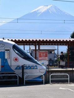 a train parked at a station with a mountain in the background