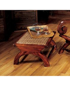 two wooden chairs sitting on top of a hard wood floor next to a small table