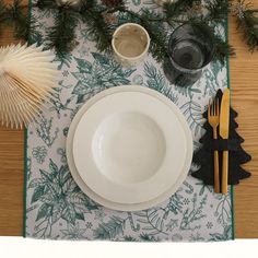 a place setting with pine cones, napkins, and other holiday decorations on the table