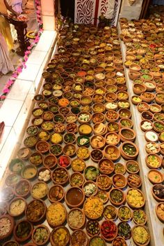 many bowls filled with different kinds of food on the floor in front of a wall