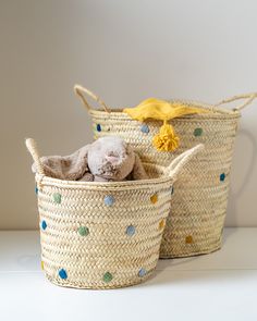 two baskets with stuffed animals in them sitting next to each other on a white surface