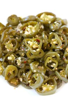 green peppers with garlic and seasoning on top, sitting on a white surface in close up view