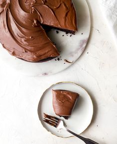 a piece of chocolate cake sitting on top of a white plate next to a fork