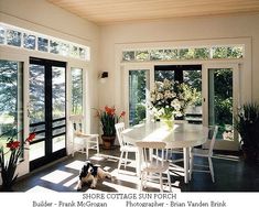 a dining room table with chairs and a dog sitting on the floor in front of it