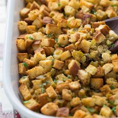 a casserole dish filled with stuffing and garnished with parsley