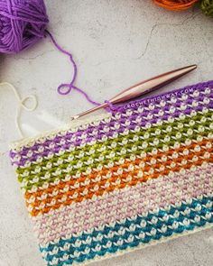 a crochet bag with yarn and scissors on the table