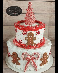 a three tiered cake decorated with gingerbreads and candy canes on top