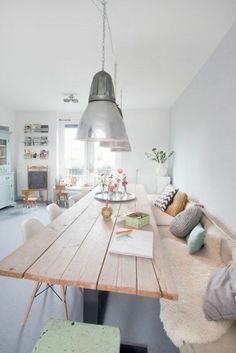 a dining room table with chairs and a bench in front of the kitchen counter top