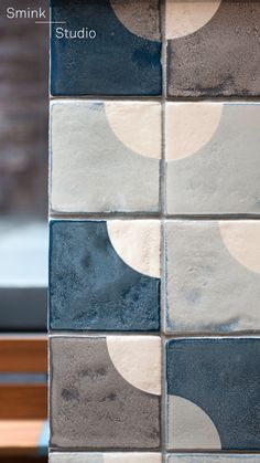 a close up of a tile wall with different colors and shapes on it's surface