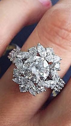 a woman's hand with a diamond ring on top of her finger and an engagement band