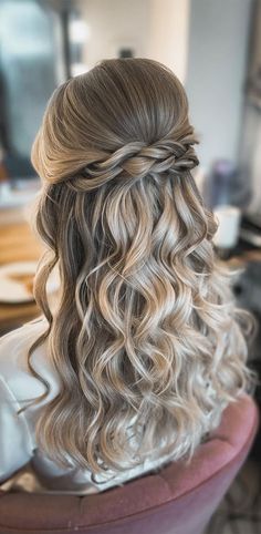 the back of a woman's head with wavy hair and braids in it