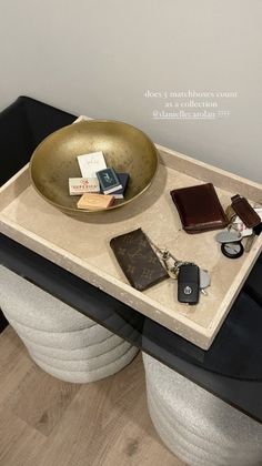 a table with a bowl, wallets and other items on it