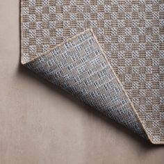 a close up view of the fabric on a rug with an interesting pattern in grey and tan tones