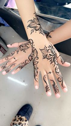 two hands with henna tattoos on them