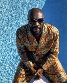 a man sitting on top of a surfboard next to a swimming pool wearing sunglasses