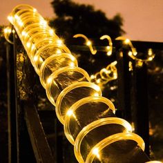 there is a long row of lights that are on the railing outside at night time