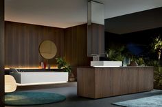 a modern bathroom with wood paneling and white bathtub in the center, surrounded by potted plants