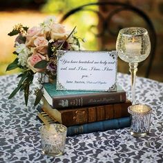 a table topped with books and glasses filled with flowers on top of eachother