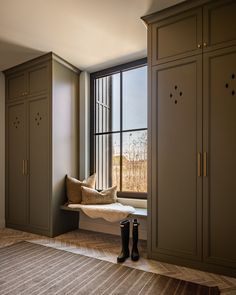 a window seat in the corner of a room with lots of cabinets and cupboards