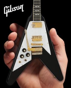 a person holding an electric guitar shaped like a rock and roll's neck with the words gibson on it