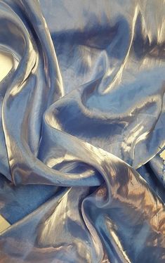 the fabric is shiny and blue with silver streaks on it's edges, as well as