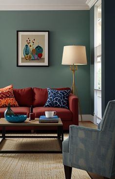 a living room filled with furniture and a painting on the wall above it's coffee table