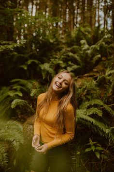 a woman standing in the middle of a forest