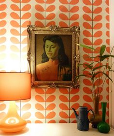 a painting hangs on the wall next to a lamp