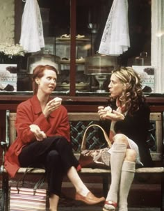 two women sitting on a bench talking to each other