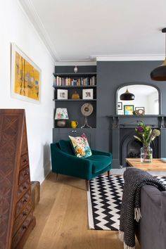 a living room filled with furniture and a fire place in front of a book shelf